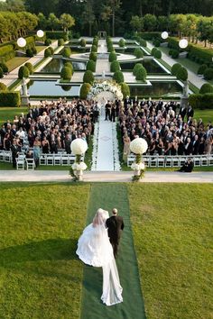 a bride and groom walking down the aisle to their wedding ceremony in front of an audience