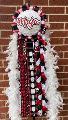 a red, white and black cheerleader's wreath hanging on a brick wall