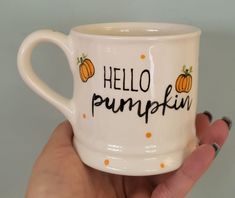 a hand holding a coffee mug with the words hello pumpkin on it