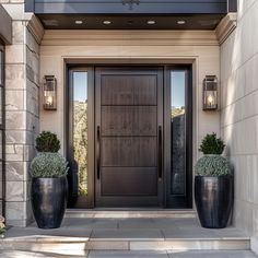 two large black planters are in front of the door