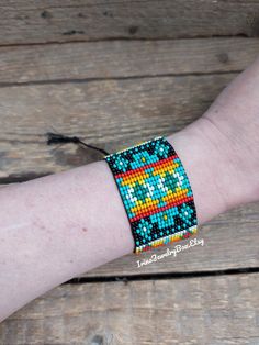 a woman's arm with a colorful beaded bracelet on top of her wrist