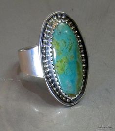 I specialize in turquoise because of its variety and warmth.  This blue green Kingman turquoise with its olive brown matrix, is perhaps, the prettiest, warmest turquoise stone I've ever had the pleasure to work with.  I also am very proud of the silverwork right down to the simple and appropriately wide shank. The ring is 1" long by 9/16" wide.  Sometimes things come together just right. Large Oval Turquoise Stone Ring, Oval Turquoise Ring With Large Stone, Artisan Green Chrysocolla Rings, Unique Green Turquoise Ring, Bohemian Oval Chrysocolla Ring, Southwestern Oval Turquoise Ring With Natural Stones, Green Oval Turquoise Artisan Ring, Bohemian Oval Turquoise Collectible Ring, Untreated Adjustable Oval Turquoise Ring