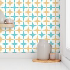 a kitchen counter with two vases on top of it and a wall paper behind them