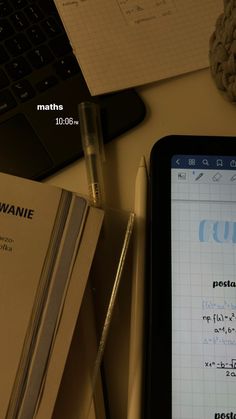 a tablet computer sitting on top of a desk next to a notebook and pen,