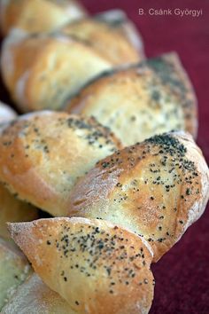 bread rolls with poppy seed sprinkles lined up on a red tablecloth