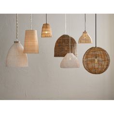 several different types of lights hanging from the ceiling in various shades of brown, beige and white