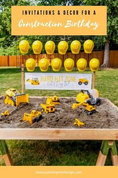 construction themed birthday party with toys in the sand and yellow decorations on top for boys