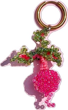 a pink beaded keychain with a tree on it's back end