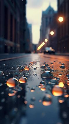 raindrops on the ground in front of a city street with buildings at night