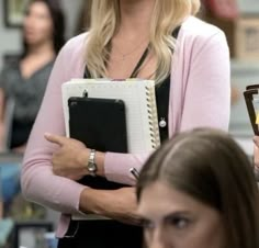 a woman is holding a binder in her hands