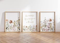 three framed pictures with flowers on them in an empty room next to a wooden floor