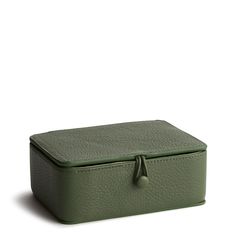 a green leather box with a bow on the top and bottom, sitting against a white background