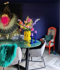 a dining room with blue walls and colorful decorations on the table in front of it