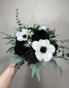 black and white bouquet being held by someone's hand