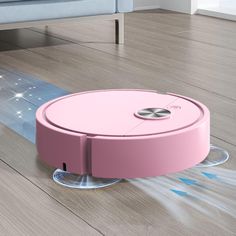 a pink robot vacuum on the floor in a living room