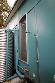 an outside view of a house with pipes and water heaters on the side of it