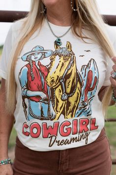 Embrace your inner cowgirl with our Cowgirl Dreaming T-Shirt. Featuring a retro western design screen printed on a comfy unisex tee, this shirt is perfect for any casual occasion. Show off your western pride with this must-have graphic tee. Styled with Branson Wide Leg Jeans 100% Cotton Machine Wash Cold ~ Tumble Dry Low Sher'a is wearing size Small Dress Layer, Retro Western, Layered Sweater, Western Design, Silver Jewelry Fashion, Denim Leggings, Wedge Boots, Denim Pant, Dress Romper