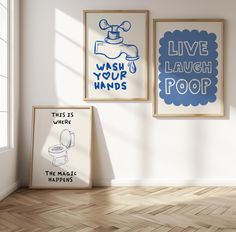 three framed posters on the wall above a toilet in a room with wooden floors and hard wood flooring