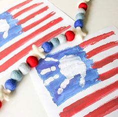 an american flag made out of yarn and beads on a white table with red, white and blue decorations