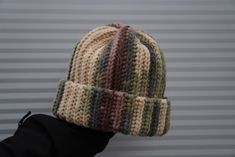 a person wearing a knitted hat on top of their head in front of a wall