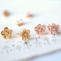 Gorgeous little Sterling Silver Plumeria flower stud earrings with Cubic Zirconia Centre and a matt finish so the stone really sparkles. The flower studs are coated in either a gold or rose gold plating on top of Sterling Silver. These tiny chic Sterling Silver flower studs are a gorgeous addition to anyone's jewellery box. The studs are finished in a polished finish with a Cubic Zirconia centre. The petals have a matt finish which contrasts beautifully with the brightness of the stone and the e Sterling Silver Flower Earrings, Rose Gold Flower, Silver Flower Earrings, Personalized Mother's Day Gifts, Flower Stud Earrings, Flower Stud, Sterling Silver Flowers, Flower Earrings Studs, Pretty Gift