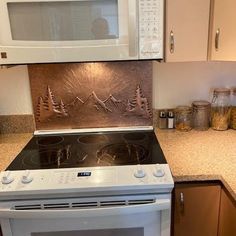 a white stove top oven sitting inside of a kitchen next to a microwave above it