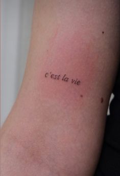 a woman's arm with the words c est la vie written on it in cursive font