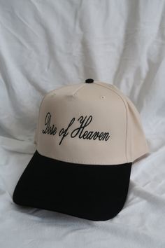 cream/black hat vintage style, adjustable featuring "Dose of Heaven" script on front This is a FINAL SALE product, not eligible for returns. Cream Snapback Hat One Size, Adjustable Cream Hats For Streetwear, Adjustable Cream Hat For Streetwear, Cream Adjustable Hat For Streetwear, Cream Adjustable Snapback Hat, Adjustable Cream Snapback Hat, Vintage Cream Baseball Cap With Curved Brim, Vintage Adjustable Brimmed Trucker Hat, Vintage Beige Baseball Cap With Flat Brim