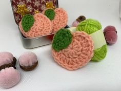 some crocheted items are sitting on a table next to an open tin can