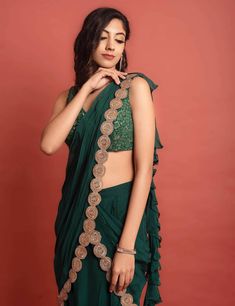 Dark green sequin and thread embroidered georgette blouse with attached soft organza ruffle at shoulder at the back, pre-pleated at center soft organza skirt with frill details and soft organza pre-pleated detachable pallu at waist and shoulder with gold lace embellishment.Dry Clean only. Festive Green Pre-draped Saree With Ruffles, Elegant Green Organza Blouse Piece, Green Ruffled Sets With Traditional Drape, Green Ruffled Blouse For Party, Festive Ruffled Blouse For Evening, Festive Green Ruffled Saree, Saree-shape Ruffled Blouse For Party, Evening Organza Lehenga With Ruffles, Green Chiffon Blouse For Party