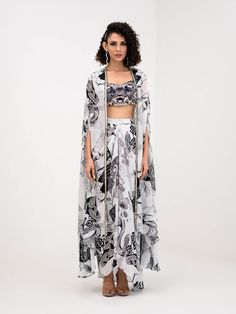 A three-piece Yang Printed Dhoti Skirt Set Paired With Bralette and Cape from the Juhi Bengani collection – Festive 2023. This gorgeous yang printed dhoti skirt is paired with a heavy embroidered yang bralette blouse. The bright black and white prints with floral work, heavy embroidery of mirror, beads, and thread sequence work enhance this crepe dhoti skirt set. This outfit is completed with a yang black and white printed cape with embroidered mirror lace border.
READY TO SHIP Printed Silk Party Sets, Summer Georgette Sets With Sheer Dupatta, Summer Sets With Sheer Dupatta In Georgette, Summer Silk Sets With Sheer Dupatta, Sheer Dupatta Sets For Summer Party, Floor-length Printed Sets For Party, Summer Designer Wear Sets With Digital Print, Summer Party Georgette Sets, Floor-length Printed Party Sets