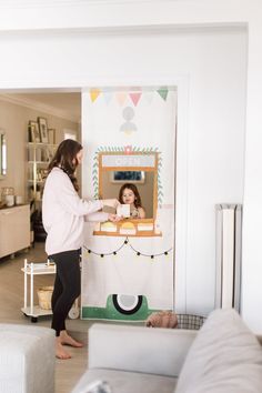 a woman standing next to a child in a room