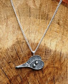 a tennis racquet pendant on a chain