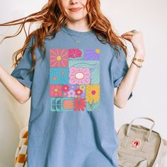 Add a touch of boho to your wardrobe with our Boho Flower T-Shirt. Featuring a beautiful floral design, this shirt will add a unique and playful touch to your style. Embrace your inner flower child and stand out from the crowd with this abstract yet stylish t-shirt. Multicolor Tops With Funny Print For Spring, Hippie Multicolor T-shirt For Spring, Bohemian Blue Printed T-shirt, Blue Bohemian Shirt With Graphic Print, Hippie Cotton T-shirt With Graphic Print, Blue Bohemian T-shirt For Summer, Bohemian Blue T-shirt For Summer, Bohemian Graphic Print Shirt For Summer, Hippie Blue Floral Print Tops