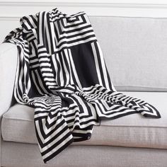 a black and white blanket sitting on top of a couch