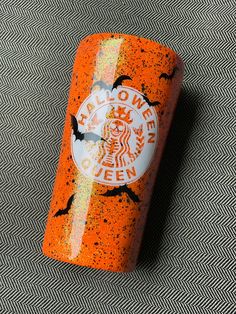 an orange and white starbucks coffee canister sitting on top of a carpeted floor