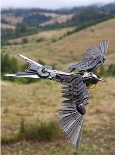 a metal sculpture of a bird flying in the air