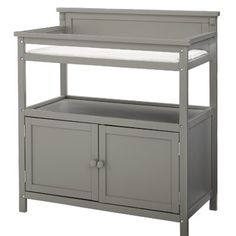 a gray baby changing table with drawers