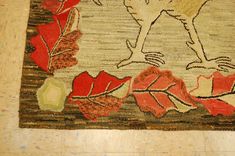 a rug with an image of a bird on top of leaves and acorns