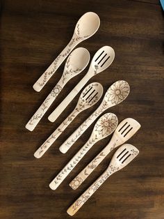 five spoons and six forks on a wooden table