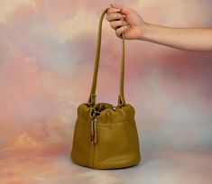 We know you. You want to carry a cute, mini bag, but you also want to fit everything in it. We can relate! Stop leaving your things at home, and start carrying the Duo bag. Not only is it large enough to fit your wallet, phone, sunglasses, and lots of accessories, this leather bucket bag has a drawstring and clasped strap so you can wear it lots of ways. In fact, that’s why we call it Duo! Our two strap settings allow for you to wear it shorter as a chic wristlet or wear it as a slouchy shoulder Trendy Handheld Bucket Bag For Travel, Versatile Bucket Bag With Phone Pocket For Daily Use, Trendy Handheld Bucket Bag For Everyday, Trendy Handheld Phone Bag For Everyday, Handheld Bucket Bag With Dust Bag, Trendy Handheld Bucket Bag With Dust Bag, Everyday Handheld Bucket Bag With Detachable Strap, Modern Handheld Bucket Bag For Travel, Modern Handheld Phone Bag For Everyday