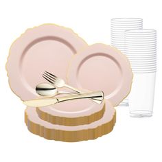 a stack of pink plates with gold rims next to a glass and silverware