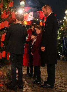 a group of people standing around a christmas tree