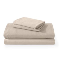 two sheets and one pillow are folded on top of each other, both in beige