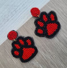 red and black beaded earrings with paw prints on the front, back and sides