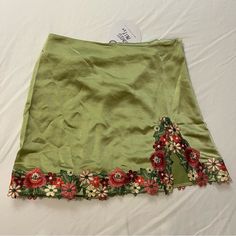 Cute Green Skirt With Colorful Flowers Around The Bottom. Zips On The Side. I Have Two Sizes: A 6 And An 8. Spring Party Skirt With Mini Hem, Fitted Floral Embroidered Skirt, Spring Party Mini Hem Skirt, Spring Floral Embroidered Mini Skirt For Party, Floral Embroidered Mini Skirt For Party, Fitted Floral Embroidered Mini Skirt For Summer, Floral Embroidered Fitted Mini Skirt, Party Mini Skirt With Floral Embroidery, Fitted Skirt With Floral Embroidery