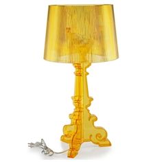 a yellow table lamp with a bird on it's side and a cord attached to the base