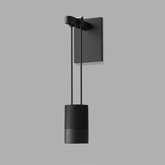 a black light fixture hanging from the side of a wall with a gray background and grey walls