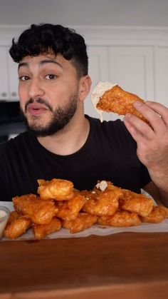 a man sitting at a table with some food in front of him and looking surprised