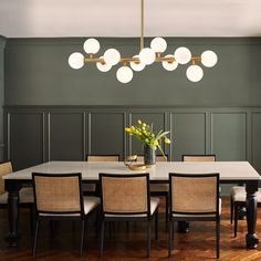 a dining room with green walls and wooden floors